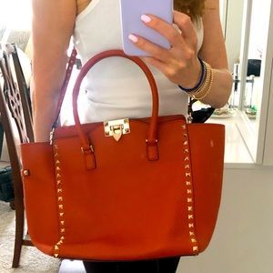 Burnt orange Valentino bag with cross body and top handle.